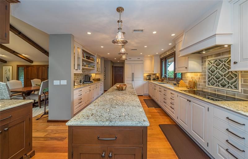 Cabinets with roll out shelves, lazy susan, crown molding, glass-fronted lighted cabinets
