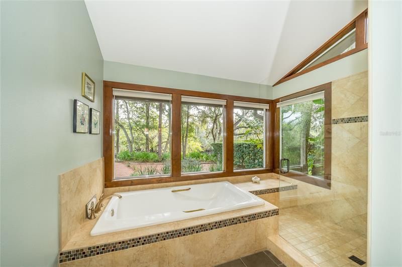 6' soaking tub, porcelain tile shower with bench to right, frameless glass door