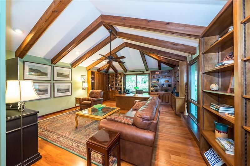 Den with Caribbean walnut floor, built-in cabinets/bookshelves, cedar wrapped ceiling beams