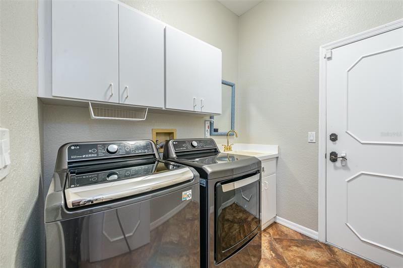 Laundry room with cabinets and utility sink.