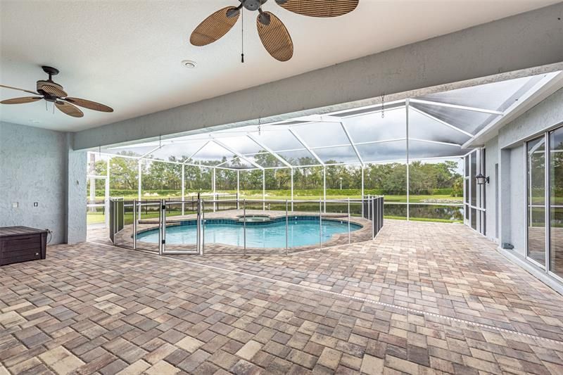 Nice covered lanai for when you want to enjoy the outdoors without the sun or bugs! Notice the beautiful pavers. Notice the child safety fence if you need it.  If not, it can be easily removed and stored.