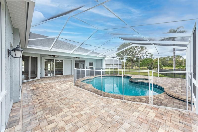 Generous size pool with spa overlooks the pond behind.