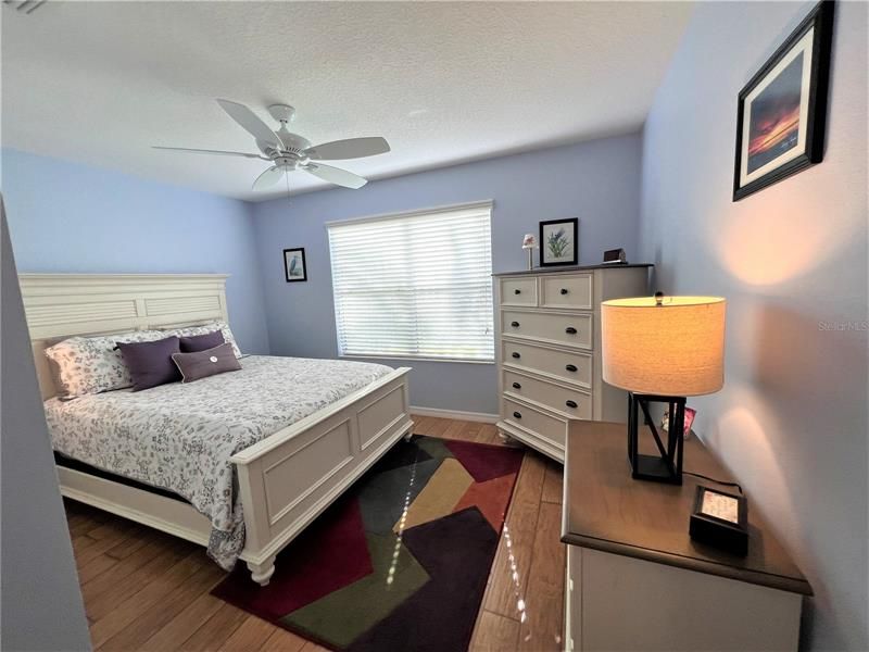 Bedroom 2 with Queen, dressers and ceiling fan.