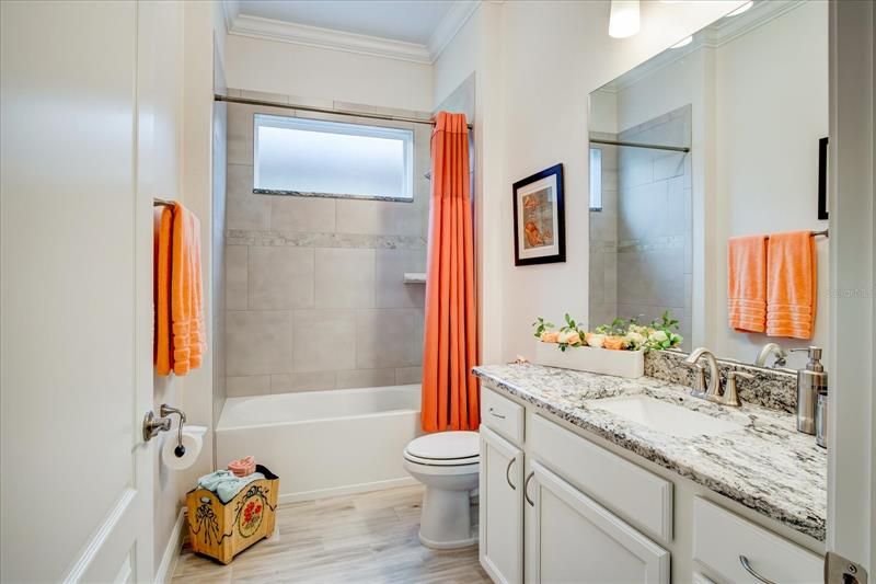Guest bath with white cabinets and granite countertop.