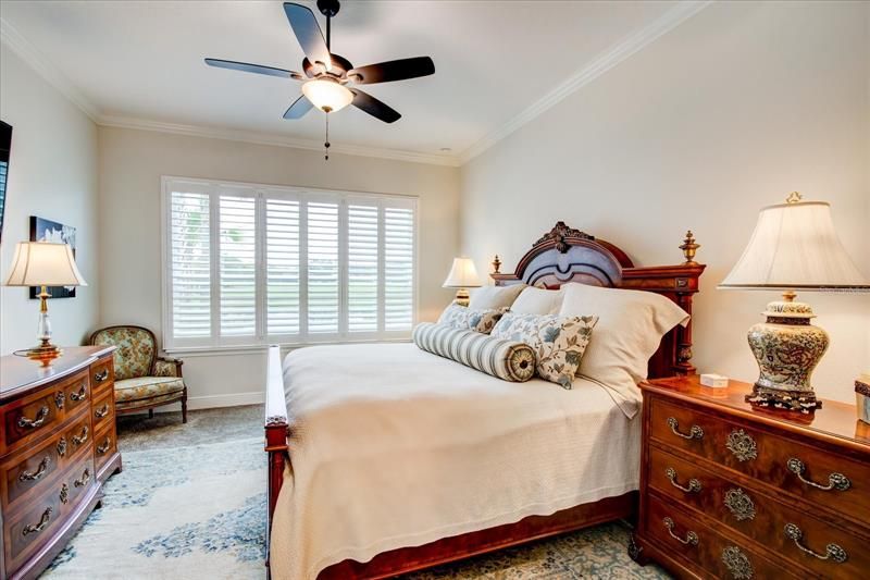 Master bedroom with plantation shutters and view.
