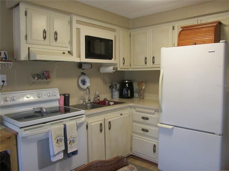 The kitchen has double sinks and comes with a full size refrigerator, glass top stove and built-in microwave.