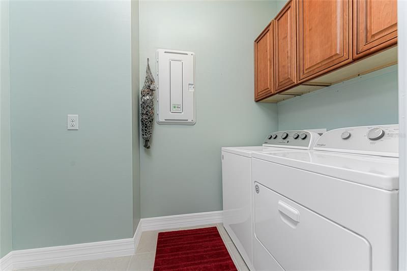 The laundry room is found adjacent to the main living area and has built-in cabinetry.
