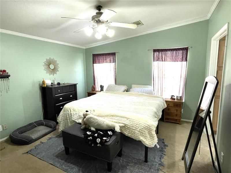 Master bedroom with fan and crown molding