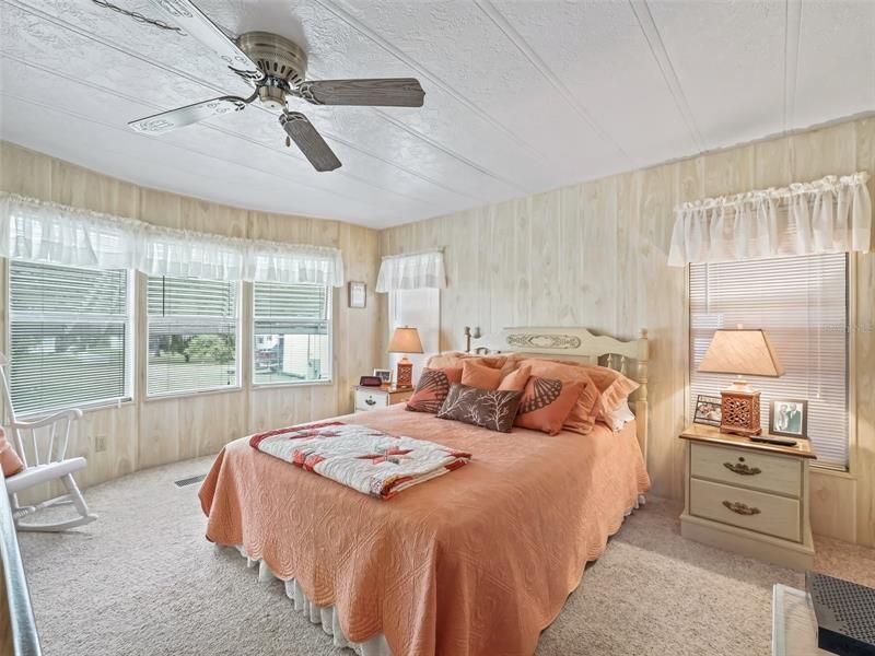 Master bedroom with bay window for sunlight and ceiling fan