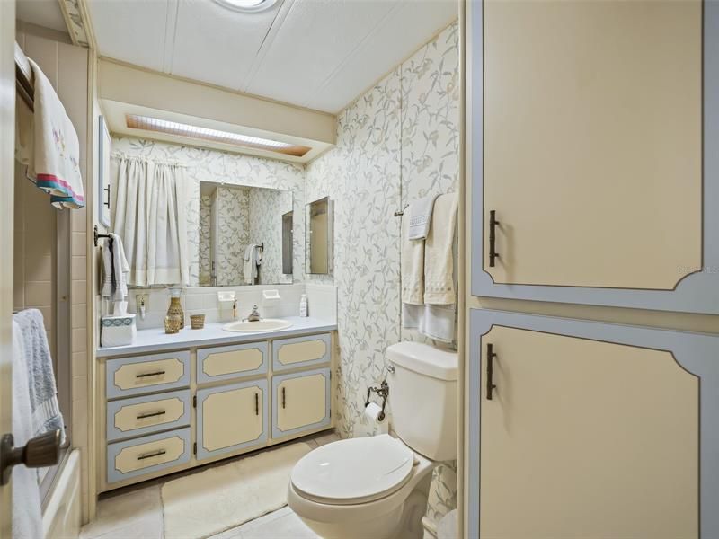 Guest bathroom with sink and laundry cabinets.