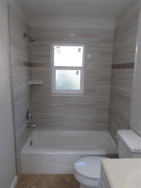 Bathroom tub/shower combo with tile walls