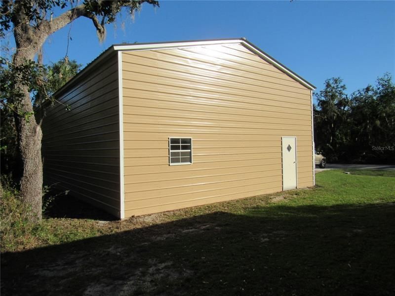 side of garage with a window and side entrance door