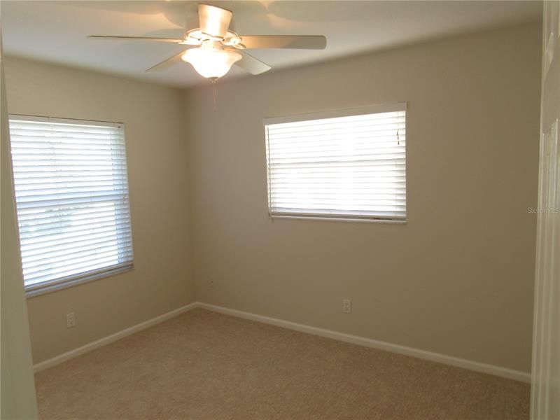 Back bedroom with 2 windows and a ceiling fan