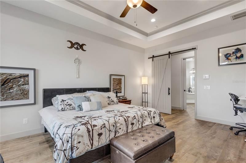 Master bedroom with barn doors leading to en-suite bath