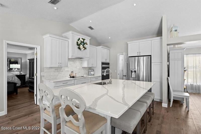 Updated open kitchen w/large quartz island that seats six, tumbled marble backsplash and quartz countertops.. New Kenmore Elite appliances and Custom Kraftmaid soft close cabinets & drawers makes cooking and family gatherings a breeze!