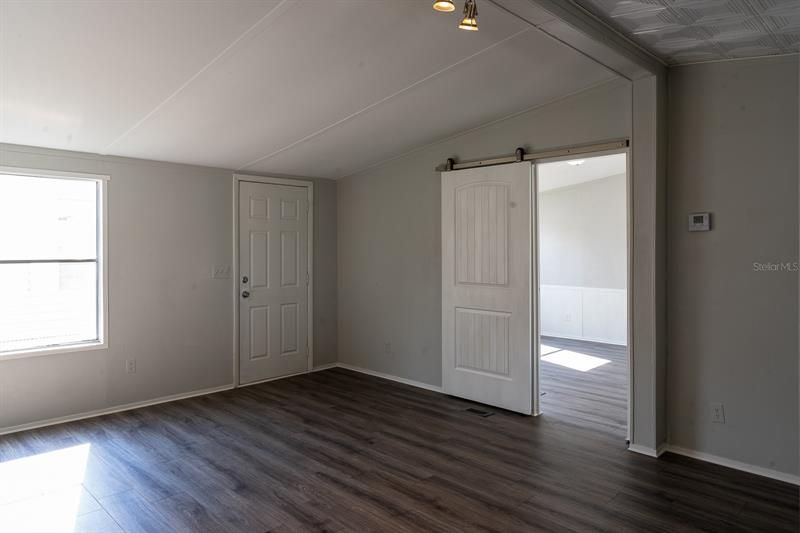 Living room with sliding barn door entry to master bedroom