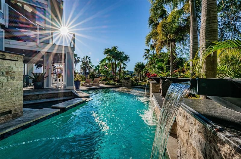 The luxurious, tropical pool with sunshelf completes this magnificent waterfront home.