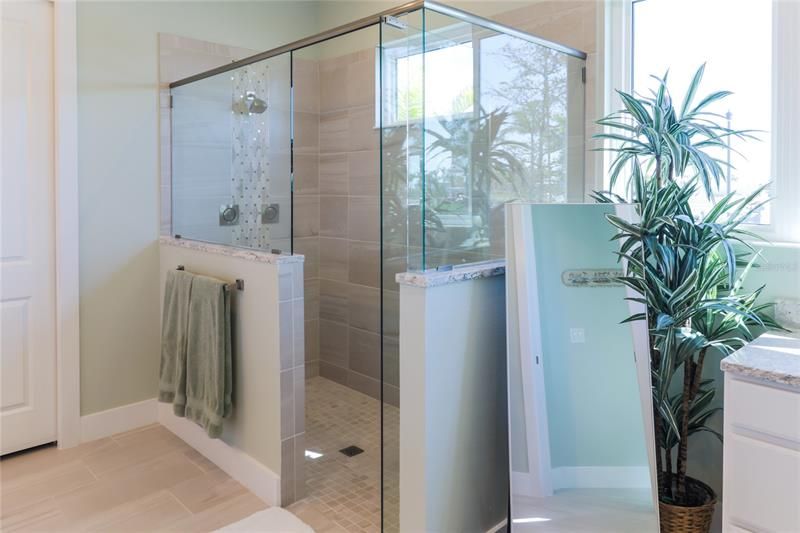 The primary bath enjoys a large tiled shower with multiple jets and shelf.