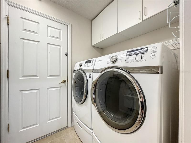 Newer laundry equipment with cabinets above
