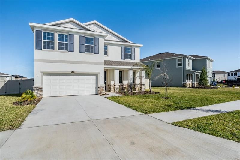 Beautiful exterior elevation with front porch, stacked stone and 2 car garage