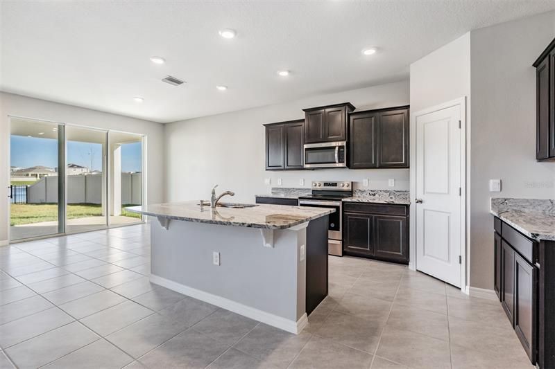 Beautiful kitchen will have brand new refrigerator.  Espresso cabinets and granite counters.