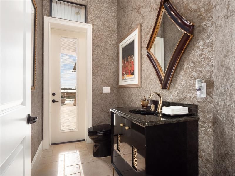 The powder room with lanai access has been updated to iwith luxury in mind and features a new sparkling feature wall, toto toilet, vanity, granite counter tops and access to the large pool lanai.