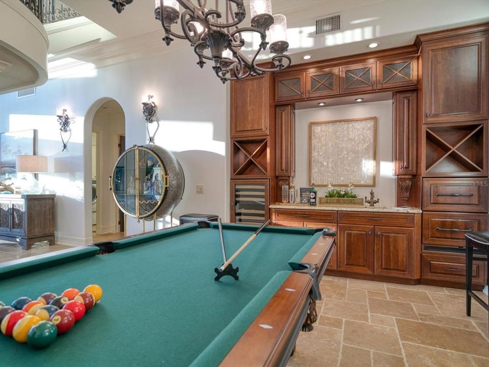 Billiards area includes built-in custom cabinets with wet bar, wine fridge, and beverage drawers.