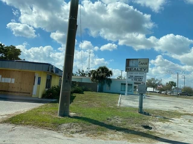 Damaged Wilson Realty sign showing side view of 4485 Tamiami Trail offices.  Almost a acre and a half of property plus buildings and 41 Hwy access    Full map of all the property and the buildings available on the Charlotte County Property web site