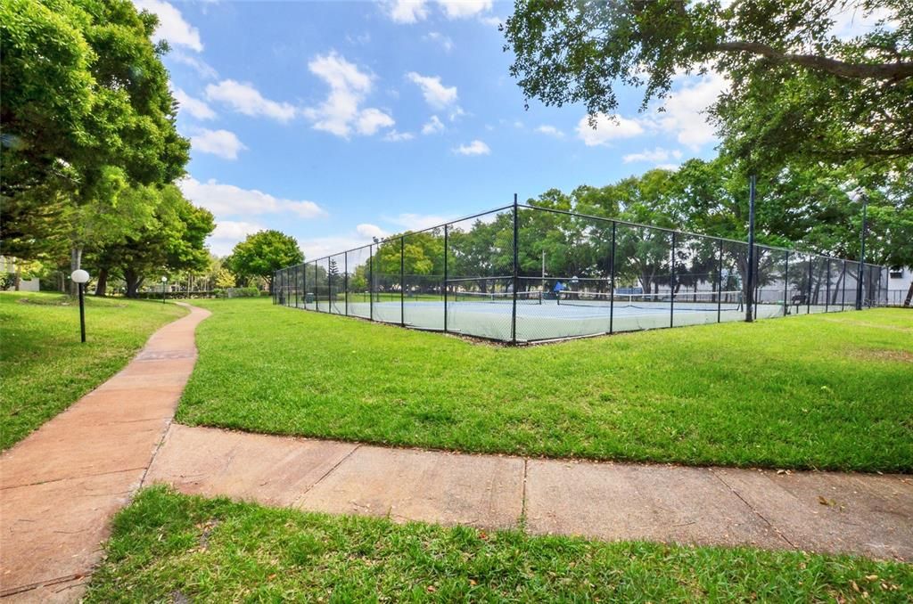 Well appointed green space with two tennis courts.