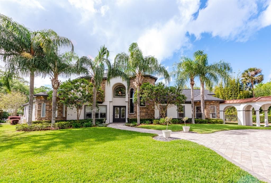 Rare opportunity for Lakefront living on Bear Gully Lake in the heart of Oviedo! This 1 ½ acre gated estate delivers a stunning main home complete with gorgeous water and sunset views, screened pool and a full guest house with an extended garage for a total of seven stalls between both homes!