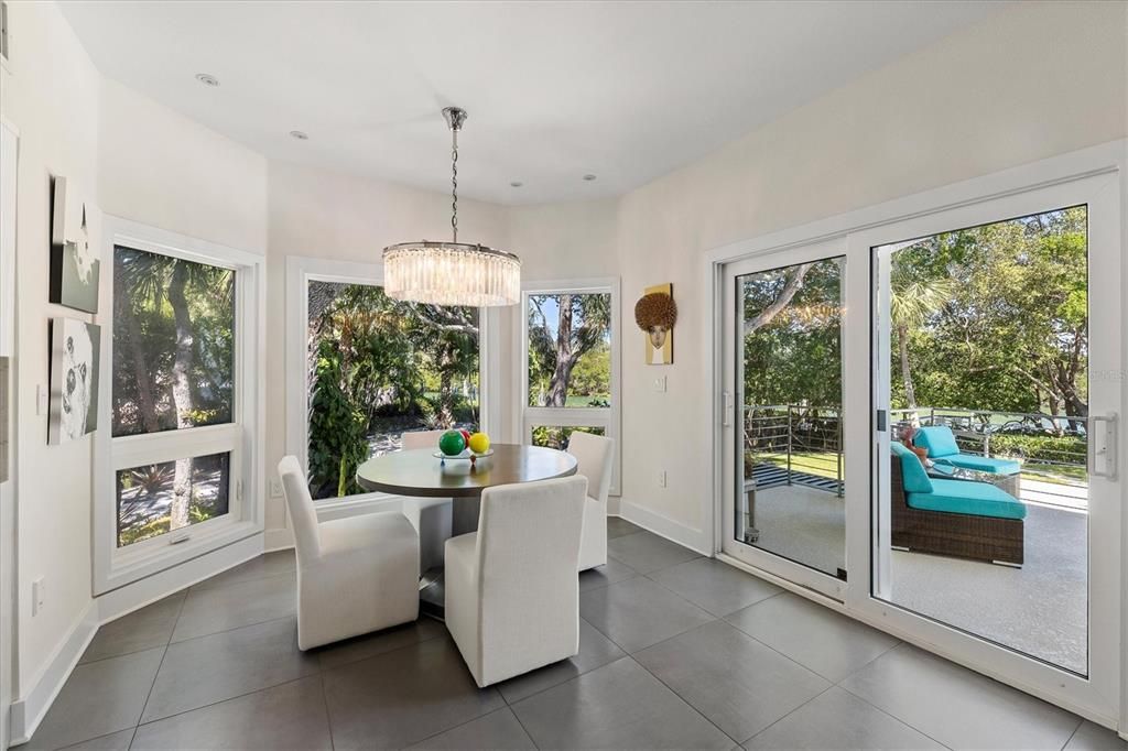 Adjacent to the kitchen and ideal for family flow or entertaining, a breakfast nook opens to the terrace overlooking the pool and waterfront