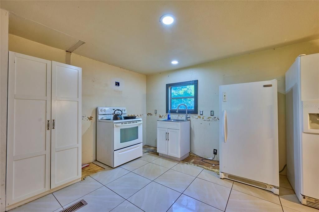 Kitchen is useable as-is, but cabinets have been removed to prep for a remodel