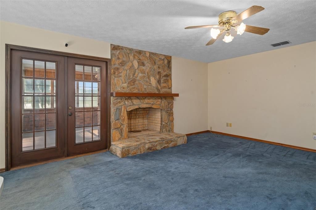 Family Room with fireplace and French Doors to Sunroom