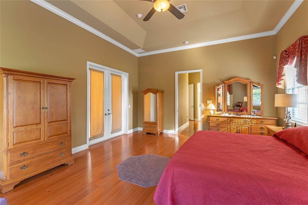 French doors lead out to the pool and lanai from the master bedroom