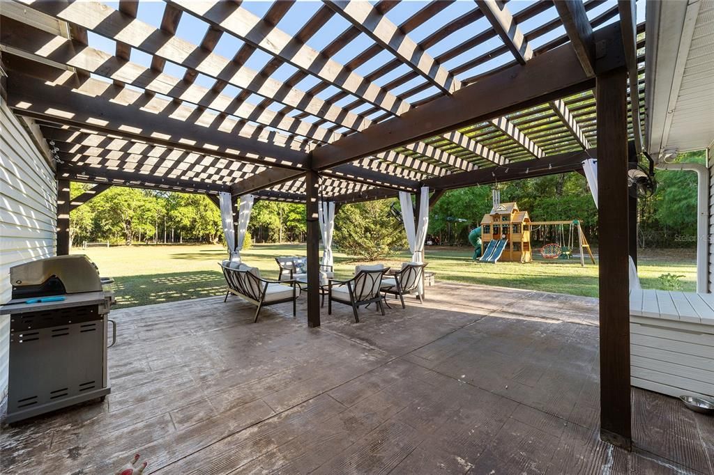 Fire up the grill and get ready for summer as this custom pergola over the back patio creates the perfect setting!