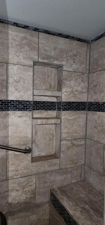 PRIMARY ACCESIBLE SHOWER WITH BUILT IN SHELVING AND BENCH