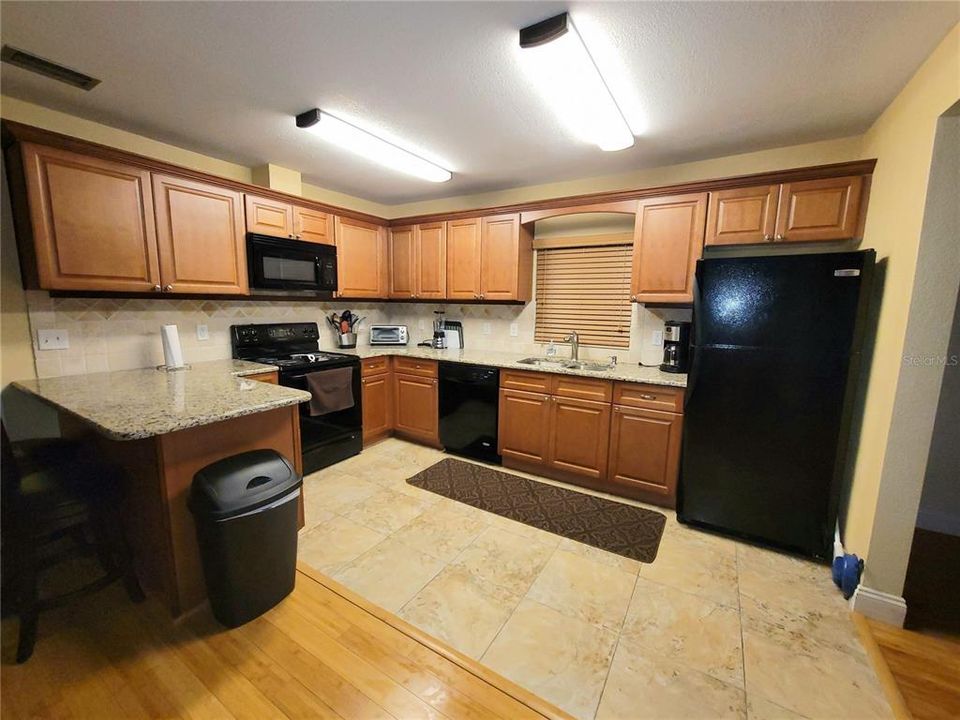 Wide opn kitchen area with plenty of cabinet space.