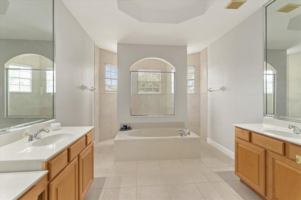 Primary bathroom with dual sinks, large walk in shower and garden tub