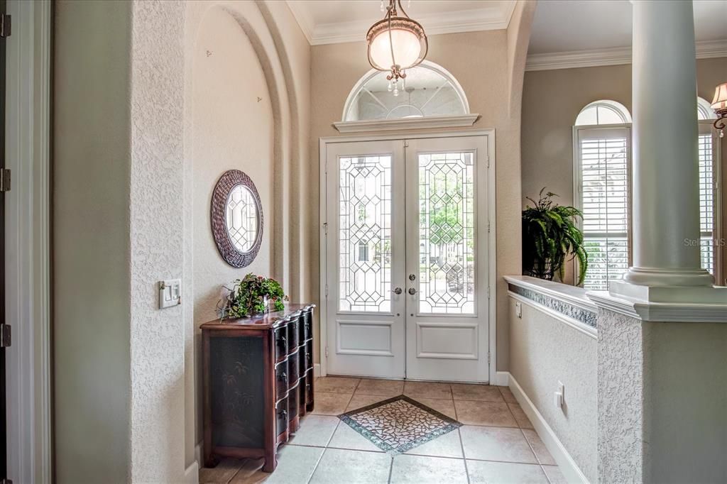 Foyer/entry features 12' ceilings, Niches, leaded glass doors & Roman columns.