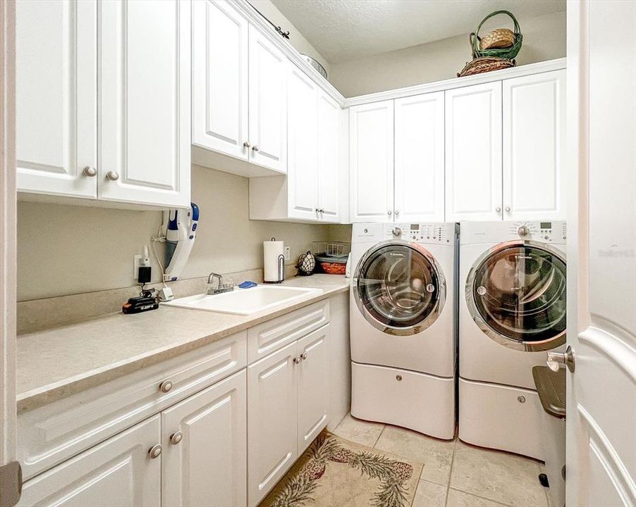 Great laundry room with plenty of cabinets and sink.