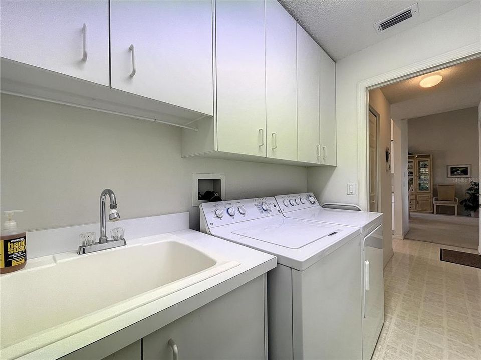 The laundry room is by the kitchen and has a large laundry sink
