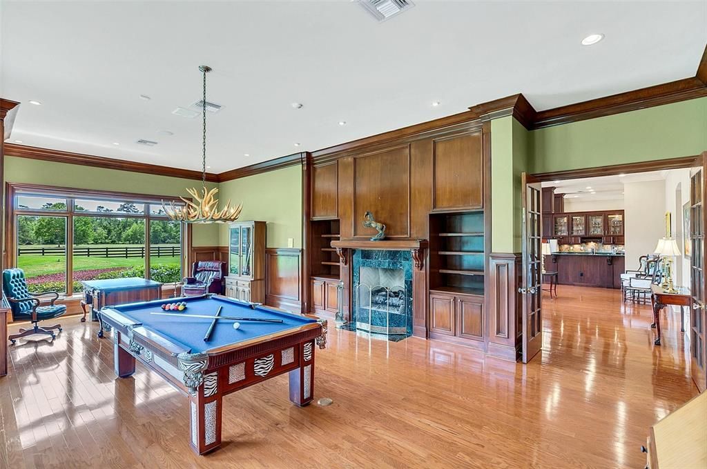 Den/billiards room with a gas fireplace and built-ins