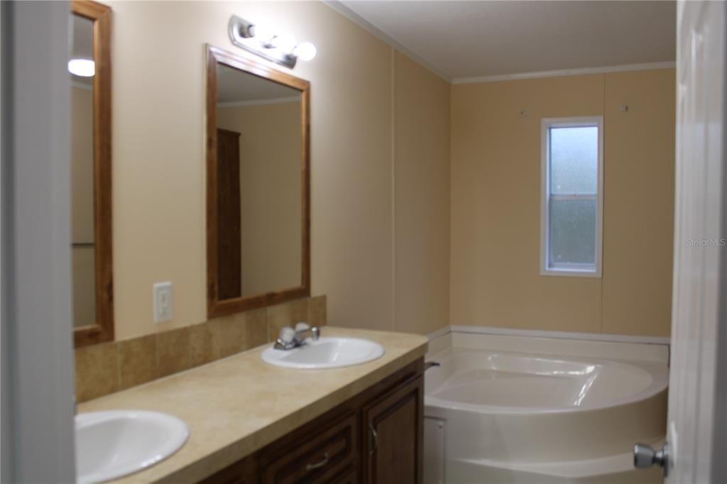 double sinks and linen shelving inside the bathroom.