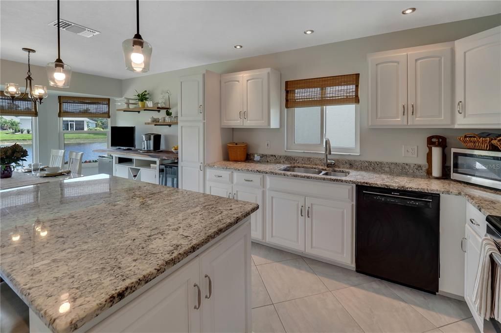 THE KITHCEN HAS GRANITE COUNTERS, UPDATED LIGHTING AND STAINLESS-STEEL APPLIANCES