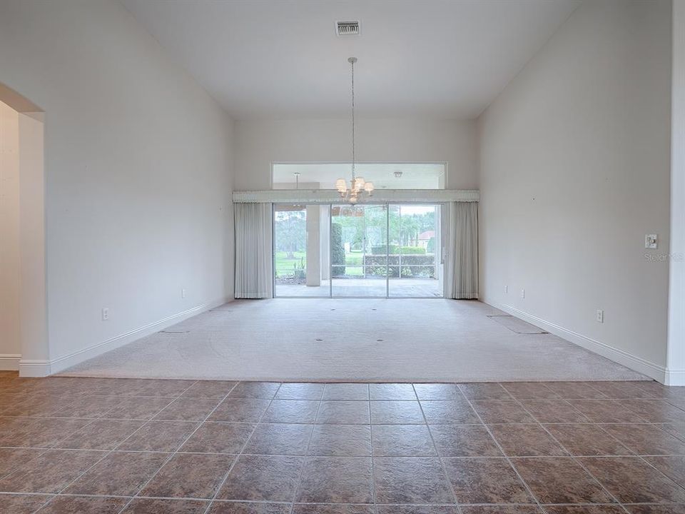 FOYER TILE LEADS TO THE FORMAL LIVING ROOM WITH SLIDING GLASS DOORS THAT OPEN TO THE LANAI.