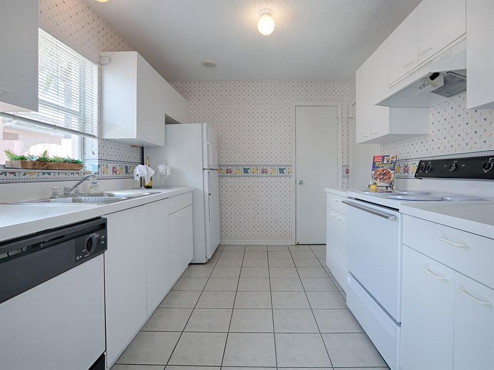 Enjoy the white cabinets with a closet pantry, electric stove, and tile floors.