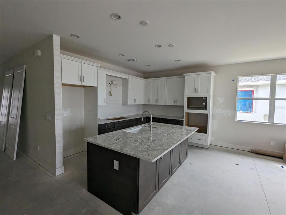 Kitchen area with upgraded granite countertops, soft-close cabinets and drawers, and upgraded alternate kitchen with wall oven and wall microwave