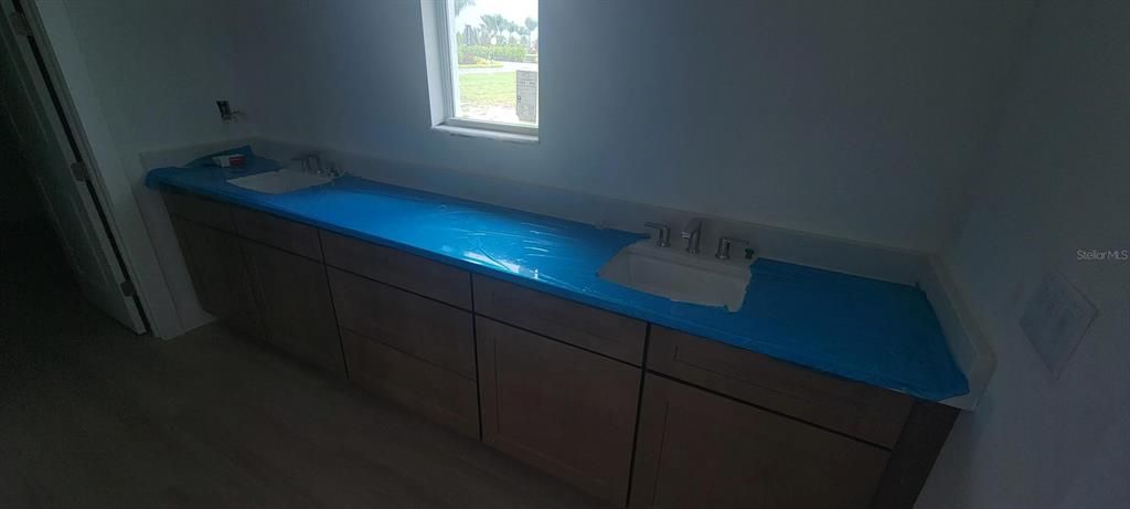 Primary bathroom dual-sinks (Countertops protected by blue cover)