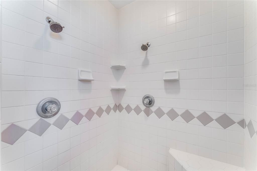 WALK-IN SHOWER WITH DUAL SHOWER HEADS AND BENCH