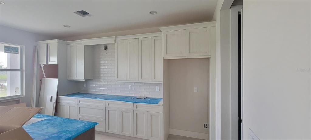 Kitchen with upgraded countertops and cabinets (countertops covered by blue plastic)